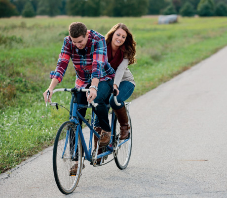 a couple riding on a tandem bicycle