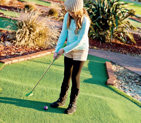 girl about to putt a golfball