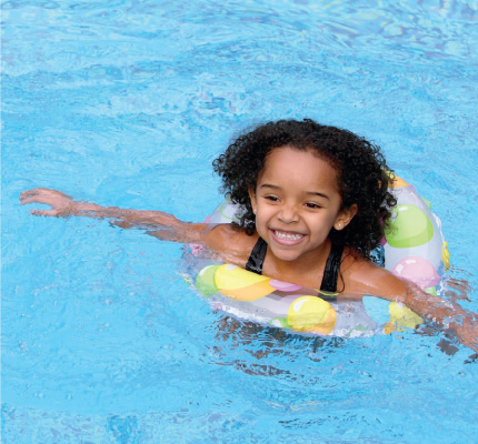 girl with a flotation device swimming in a pool