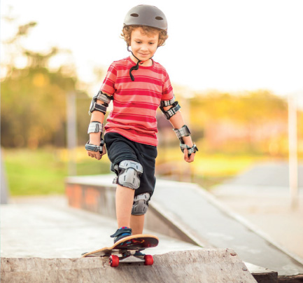 kid skateboarding on a ramp with protective gear on