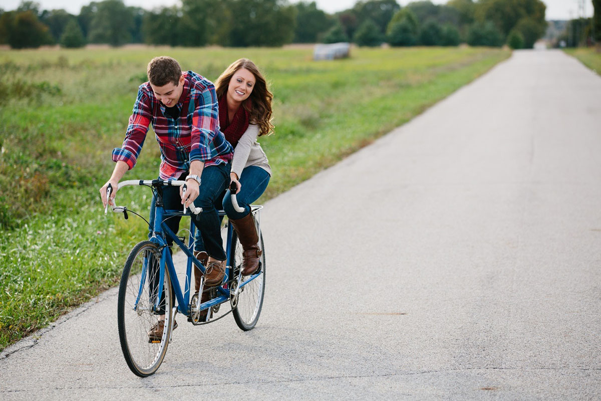 young couple riding tandem bicycle